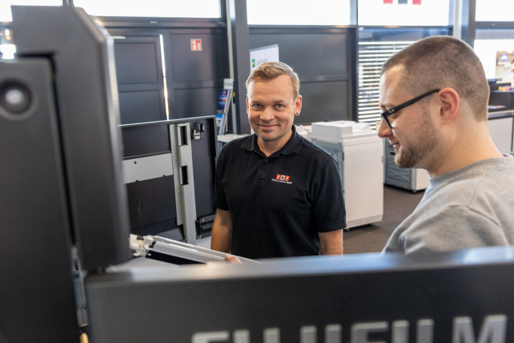 Zwei Service-Techniker von Kunze & Ritter vor einem Fujifilm Produktionsdrucksystem