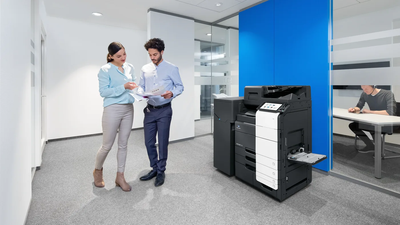 Zwei Mitarbeiter im Büro vor einem Multifunktionsgerät Konica Minolta bizhub